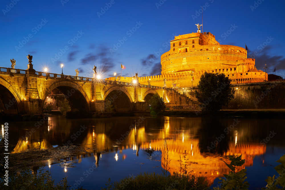 Die Engelsburg in Rom, Italien bei Nacht. Zu sehen ist der Tiber und die Engelsbrücke. Aufnahme in der blauen Stunde. 