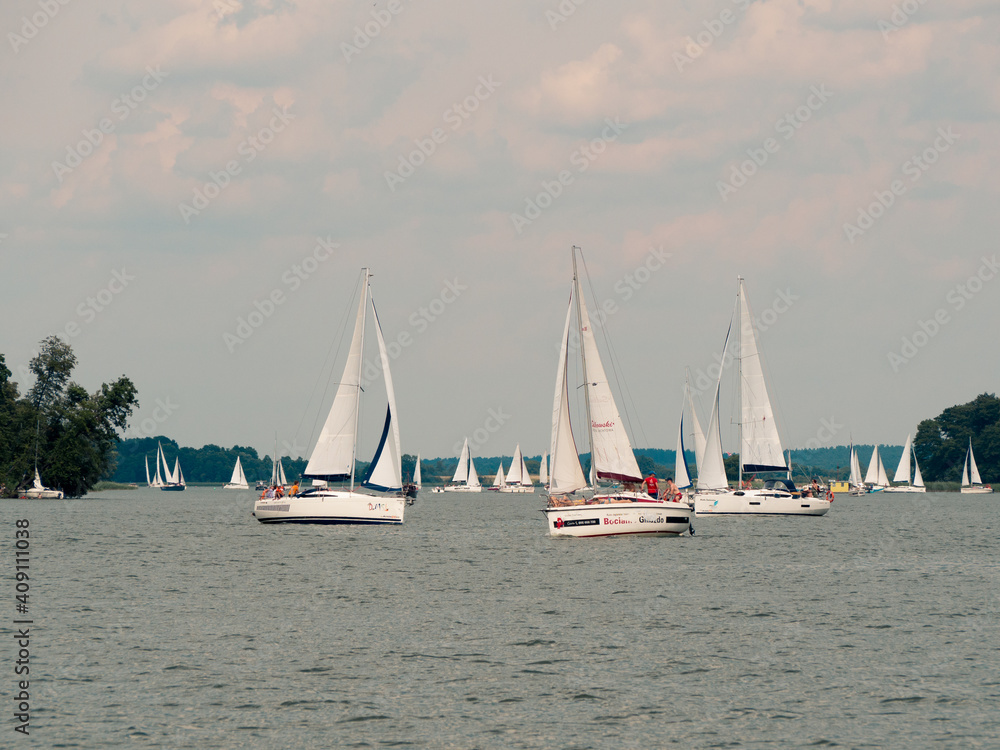 Beldany lake, Masuria, Poland, 28 of July 2020. Many yachts sailing during windy summer day. Beldany lake, Masuria, Poland, 28 of July 2020. Many yachts sailing during windy summer day.