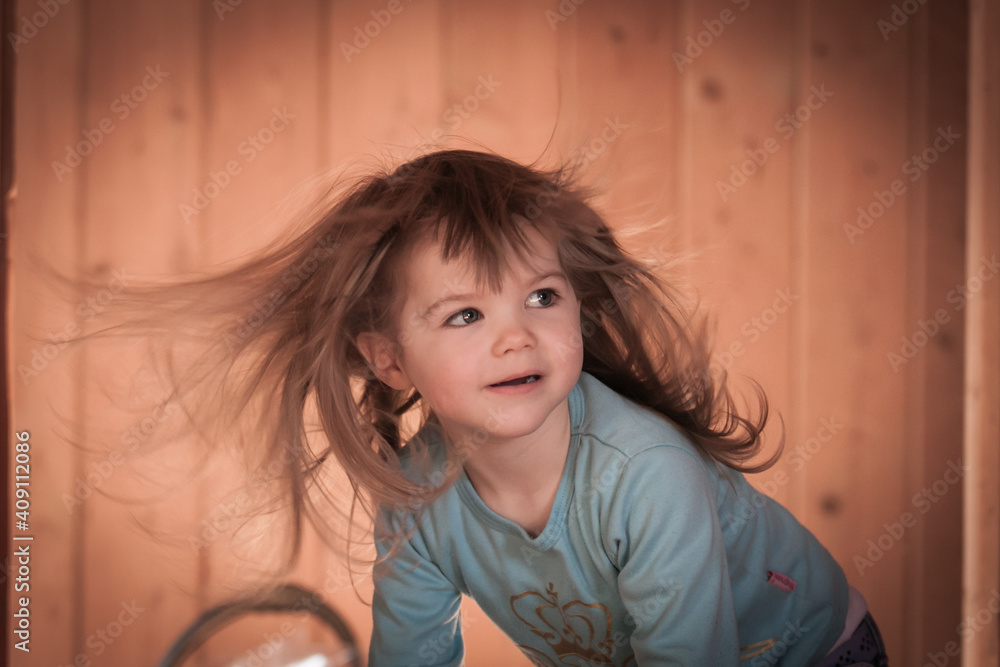 Mädchen mit fliegenden Haaren über einem Staubsauger Mädchen mit fliegenden Haaren über einem Staubsauger