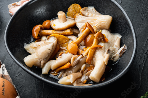 Wild mushrooms Boletus edulis and cap boletus in a jar, on black background