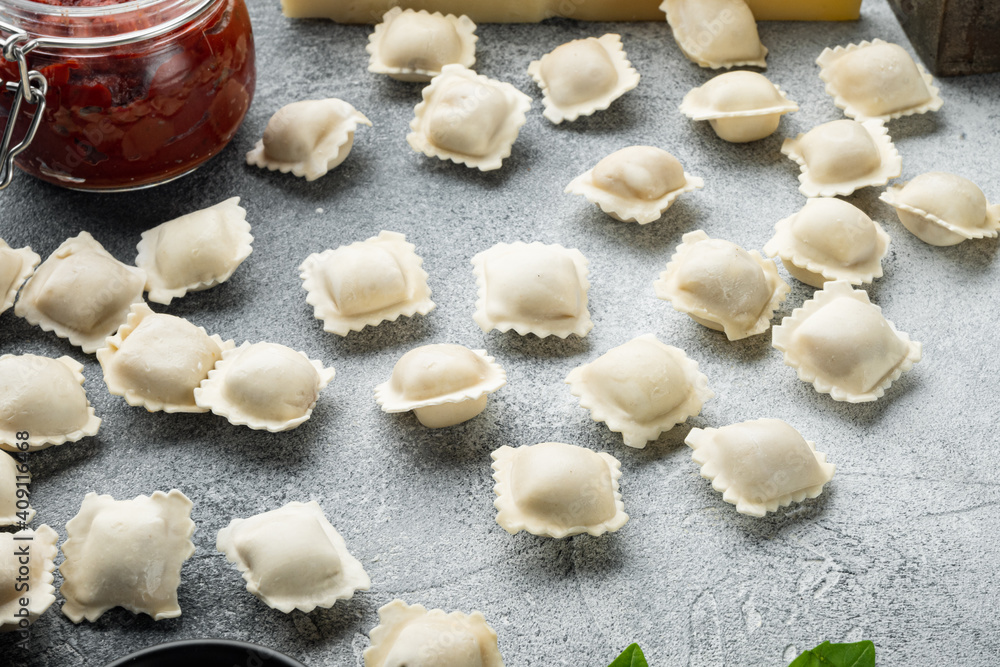 Tasty raw ravioli with flour and basil, on gray background , with copyspace  and space for text