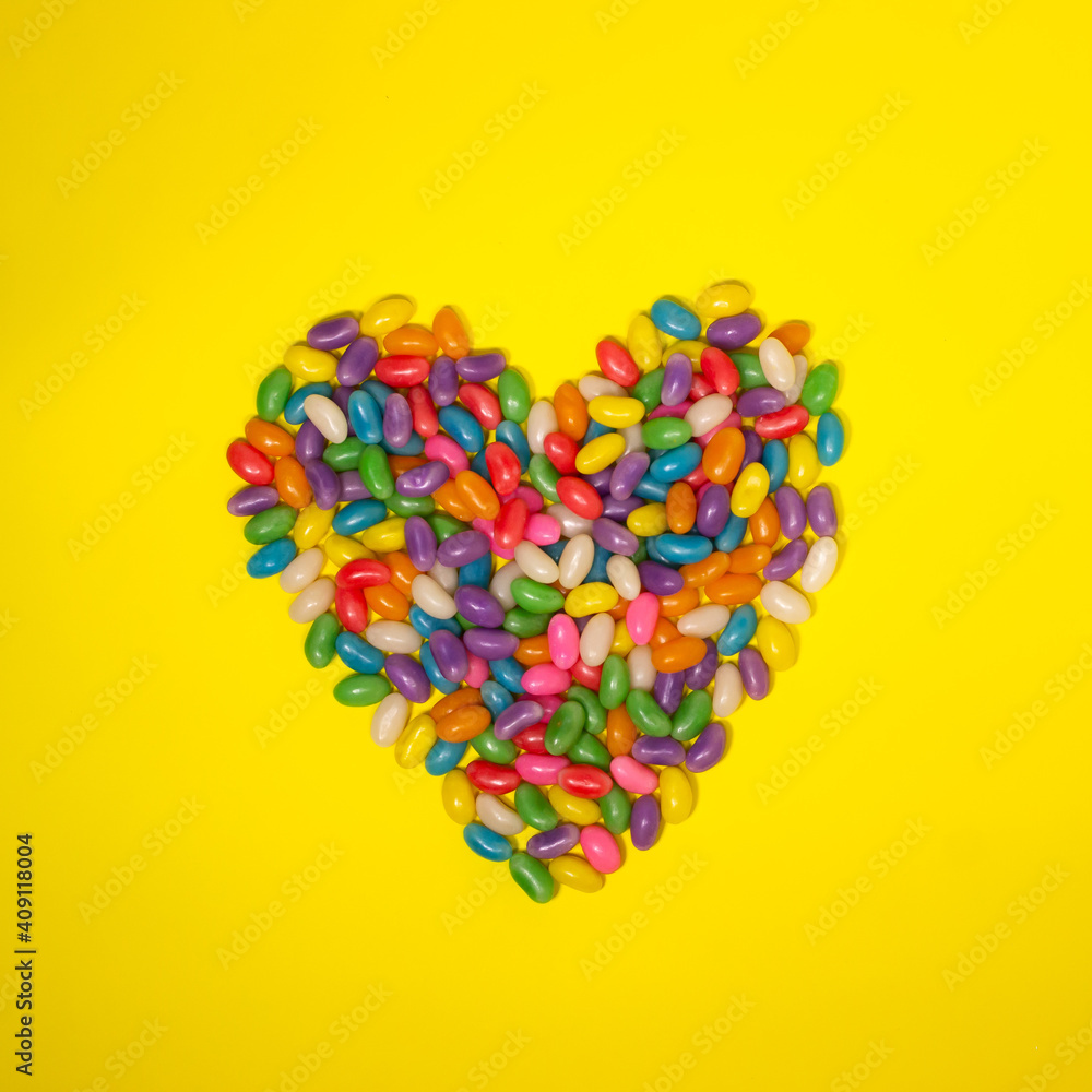Corazón de caramelos sobre fondo amarillo