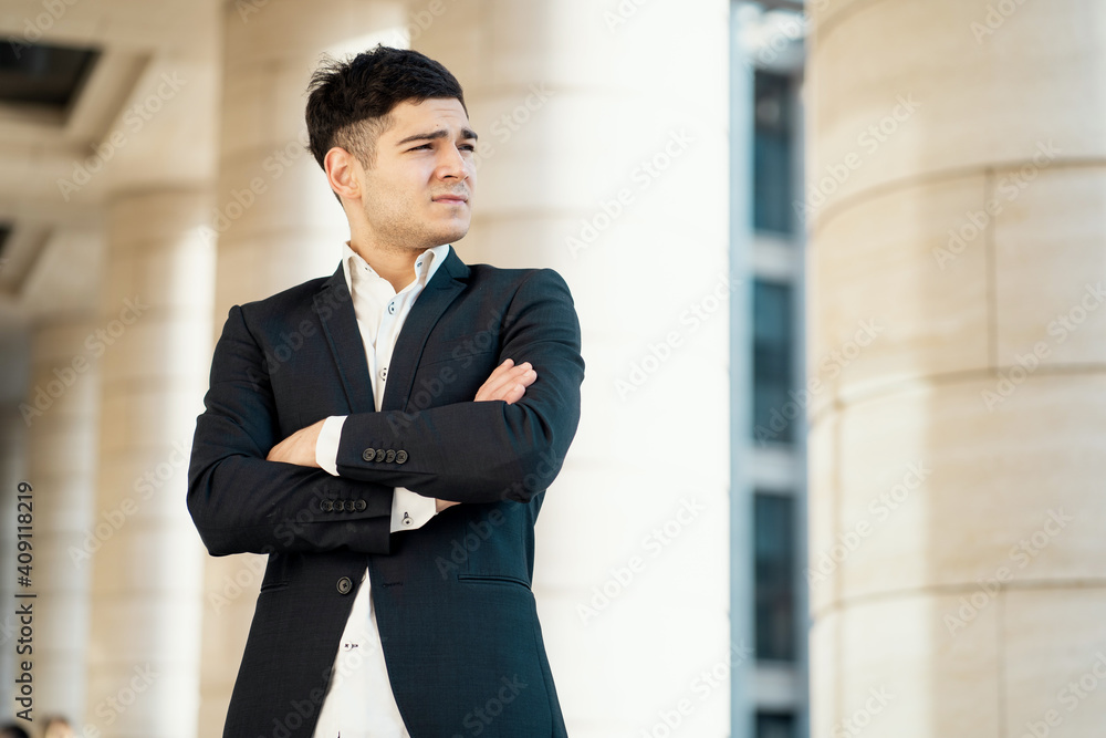 works in a bank in the city center. Dark-haired appearance. Sunny day of the week. the confident finance director is a man in a black business suit and white shirt. works in a bank in the city center. Dark-haired appearance. Sunny day of the week. the confident finance director is a man in a black business suit and white shirt.