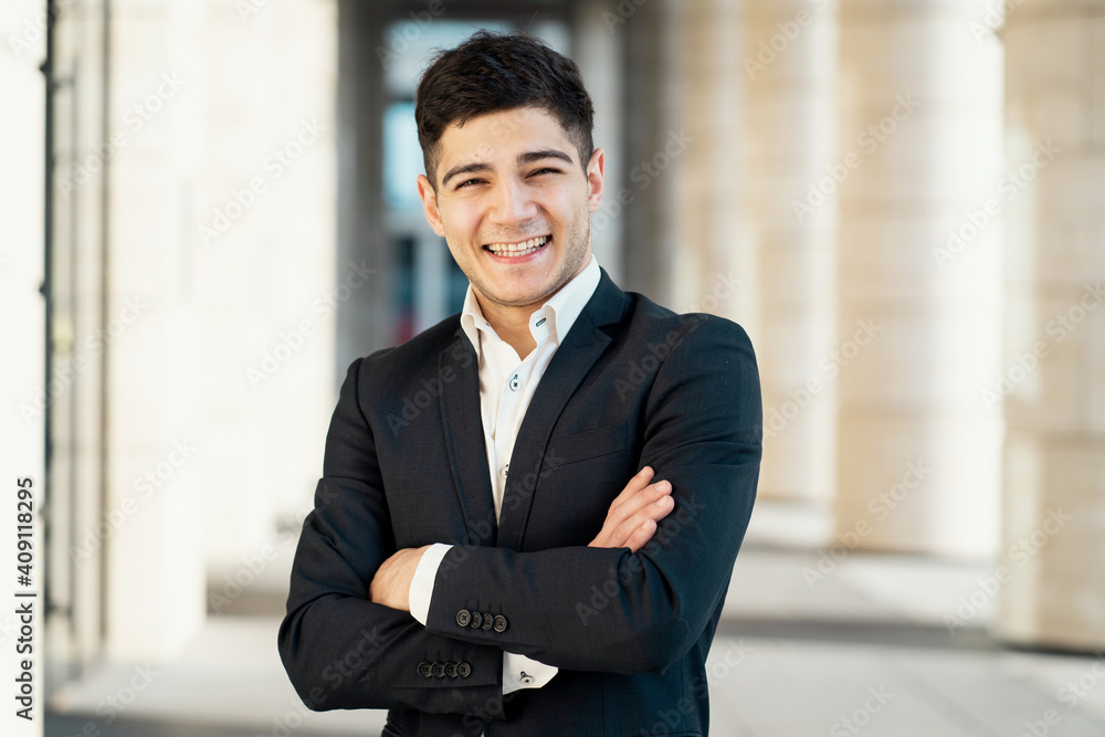 works as a manager in a bank in the city center. Dark-haired appearance. Sunlight. portrait of a man in a black business suit and white shirt smiling.