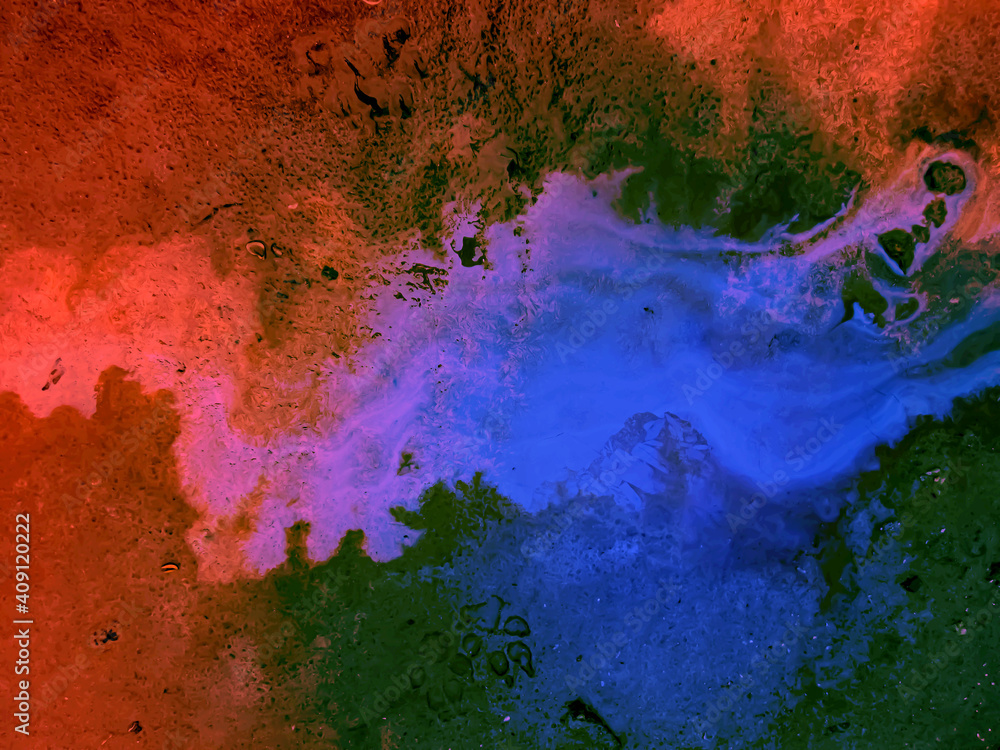 Colored streaks of liquid. Stock photo with multicolored abstraction. Red, green, and blue.