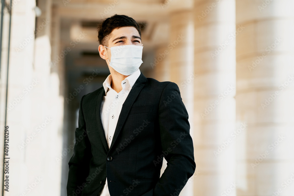 the businessman and the coronavirus wore a protective mask on his face against the virus, bacteria, microbes, infections and flu. He's standing there in a black business suit. copy space the businessman and the coronavirus wore a protective mask on his face against the virus, bacteria, microbes, infections and flu. He's standing there in a black business suit. copy space