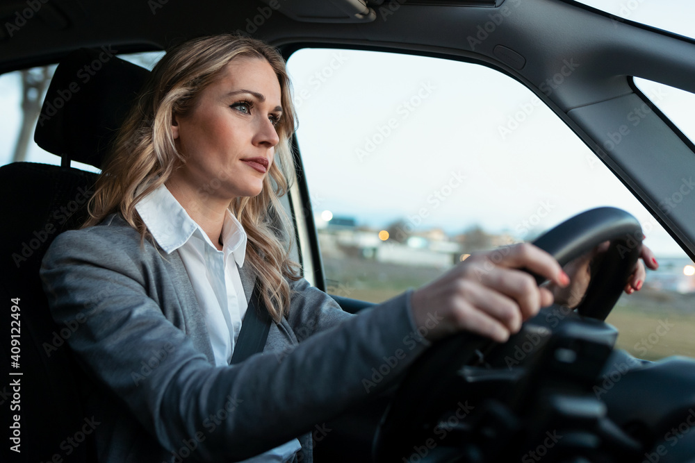 Beautiful mature woman driving her car in the city. Beautiful mature woman driving her car in the city.