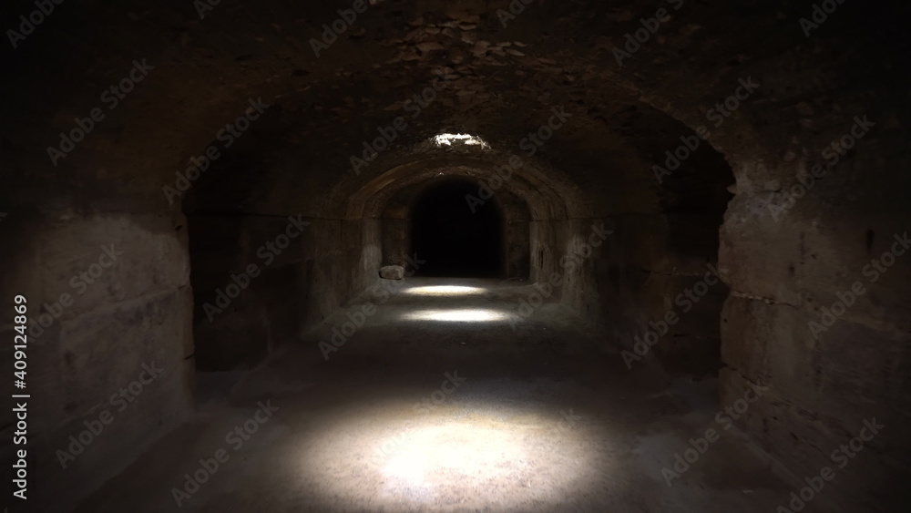 Pass through a long and dark Roman basement. Basement under the amphitheater in El Jem, Tunis. Ancient roman building. The camera is approaching