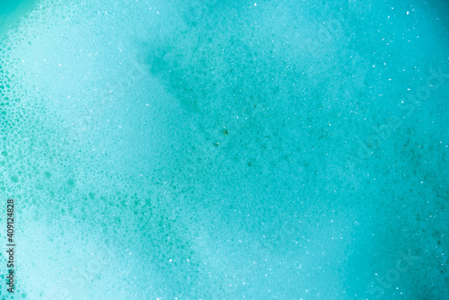 water foam and bubbles of blue color as background. cosmetology concept