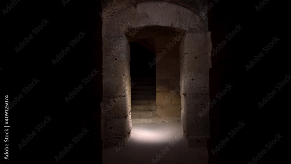 Pass through a long and dark Roman basement. Basement under the amphitheater in El Jem, Tunis. Ancient roman building. The camera is approaching