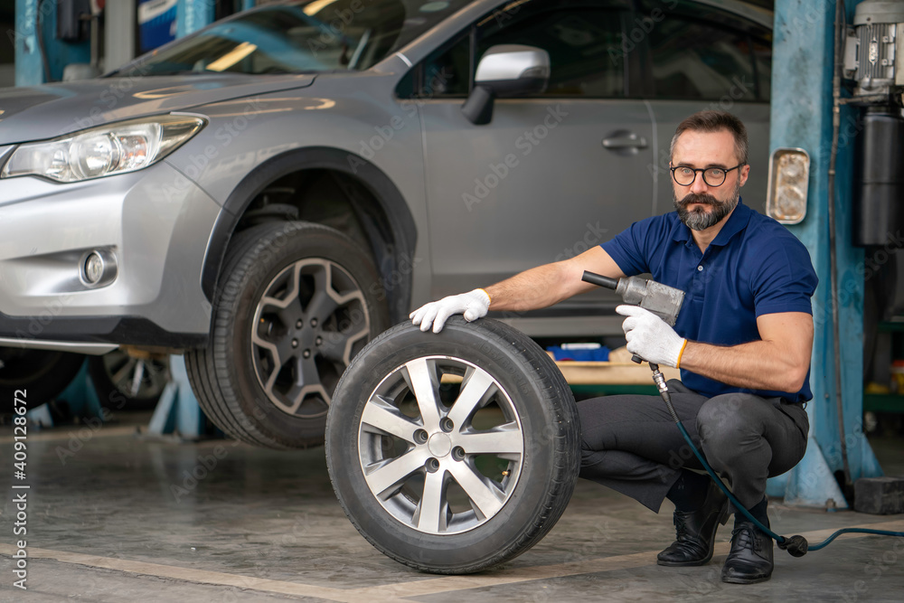 A mechanic holding the tires in the garage A mechanic holding the tires in the garage