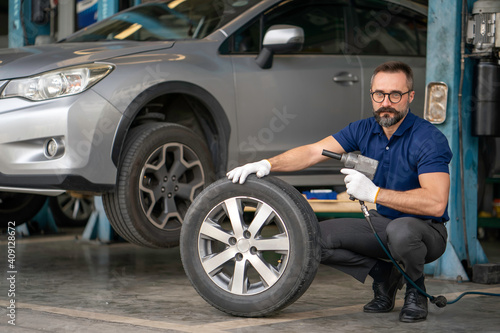 A mechanic holding the tires in the garage