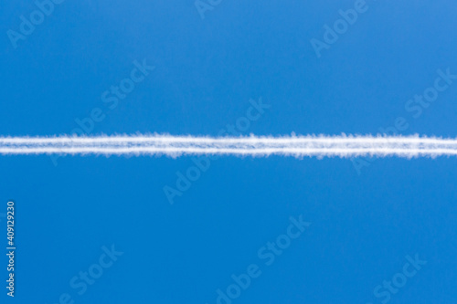 Jet airplane contrails trails on blue sky background © sanchacampos