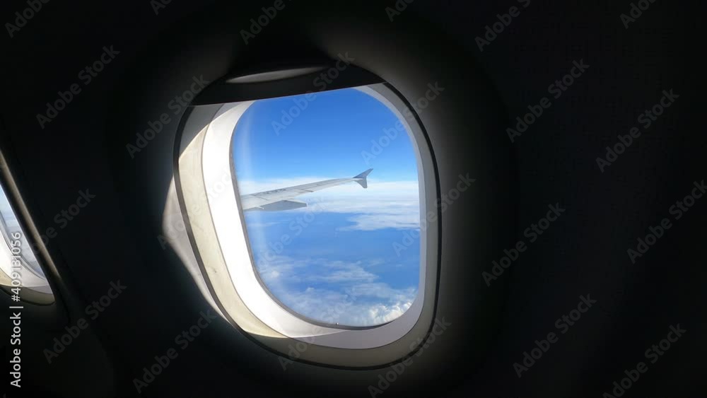 View of beautiful clouds and wing of airplane from window, airplane window with cloudy sky behind. Royalty high-quality free stock video footage looking through window aircraft during flight in wing w View of beautiful clouds and wing of airplane from window, airplane window with cloudy sky behind. Royalty high-quality free stock video footage looking through window aircraft during flight in wing w