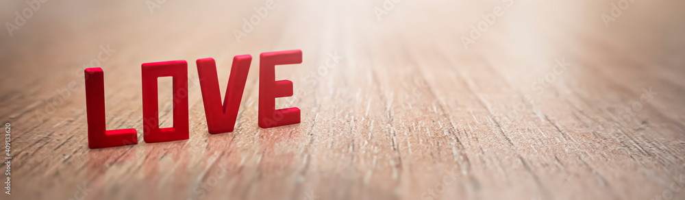 Red letters that say love on a rustic wooden table on Valentine's Day