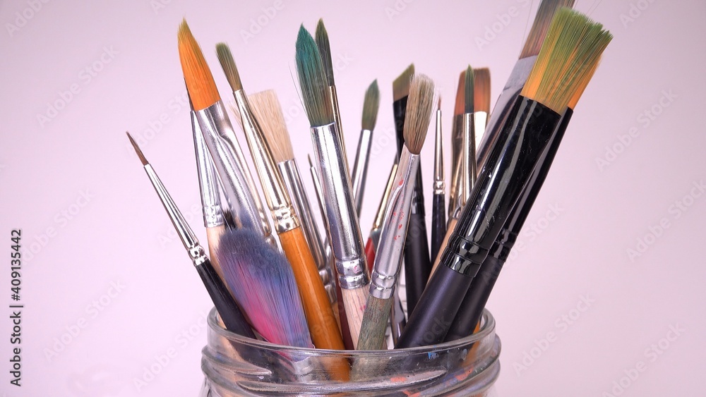 Obraz premium Multiple Painting Brushes Set for Watercolor or Acrylic Paints Standing in a Glass Jar