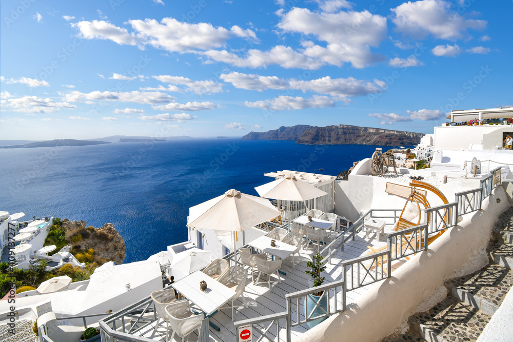 View of the Aegean Sea and Santorini caldera from a whitewashed terrace overlook in Oia, Greece, and the island of Santorini.