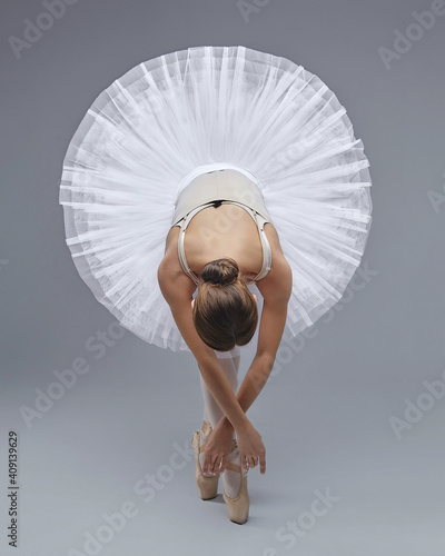 attractive ballerina poses gracefully in the studio on a white background