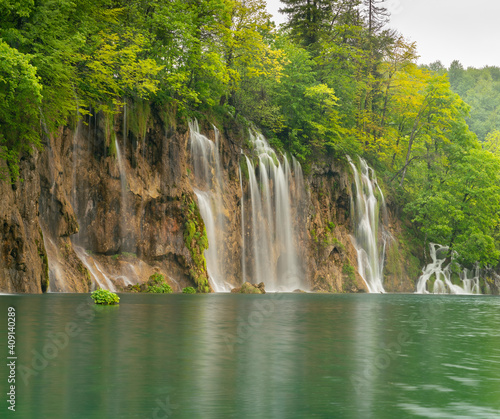 long exposure shot of a waterfall and lake at plitvice lakes national park on a rainy spring day