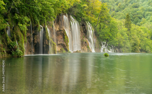 long exposure wide shot of a waterfall and lake at plitvice lakes national park on a rainy spring day