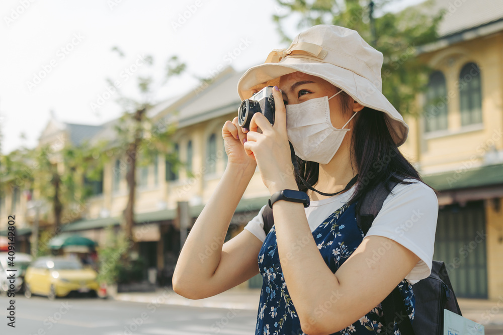 Traveler, travel young asian female, woman or girl using camera take photo ancient location street, city tourism on sunny day..Backpacker tourist, holiday trip, summer holiday or vacation concept.