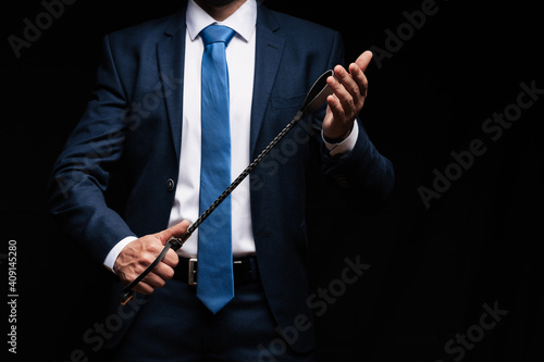 Photos male dominant holds a leather whip Flogger for hard BDSM sex