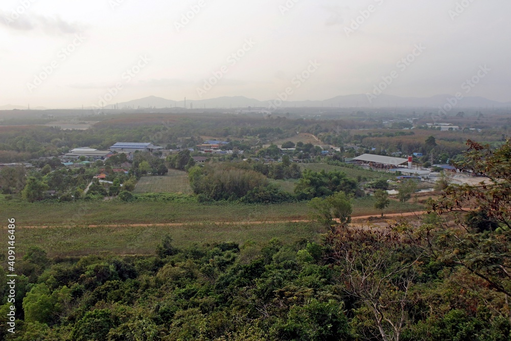 Landscape view across countryside and small factories. Location is Rayong region in Thailand.