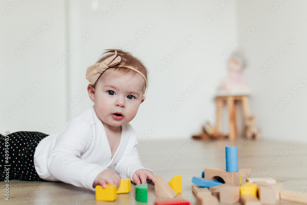 Little kid playing with colorful wooden building blocks. Blurred background Little kid playing with colorful wooden building blocks. Blurred background