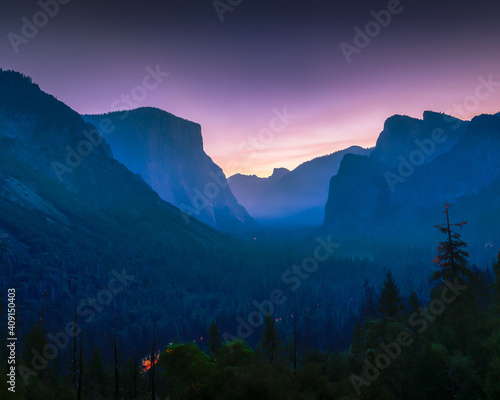 Pink sunrise at Tunnel View at Yosemite. Car lights in valley.