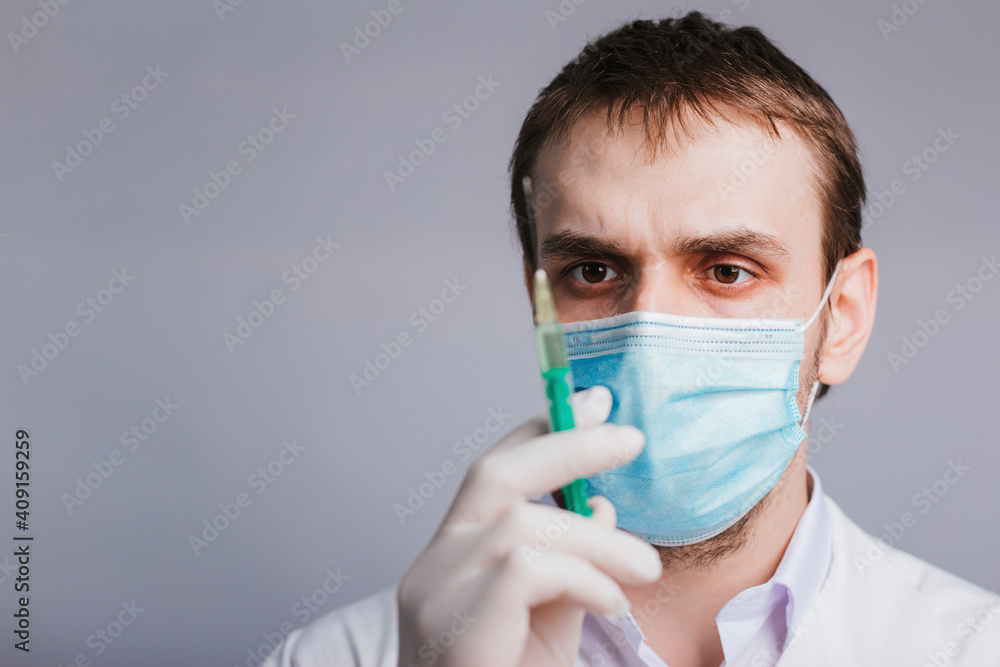 The doctor holds a syringe with a vaccine. Vaccination and immunization of the population against coronavirus. Studio photo The doctor holds a syringe with a vaccine. Vaccination and immunization of the population against coronavirus. Studio photo
