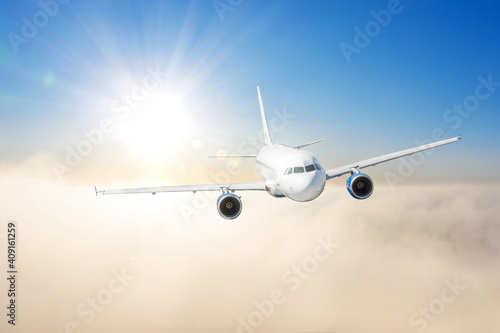 Civil airplane flying above clouds in sunset light. Concept of fast travel, holidays and business.
