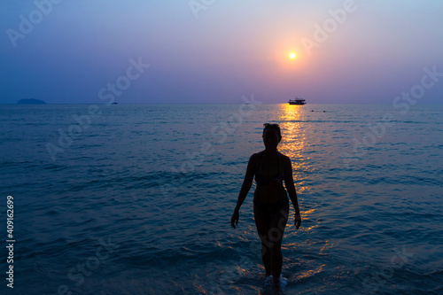 Fototapeta Naklejka Na Ścianę i Meble -  Sunset evening and traveler walk on beach