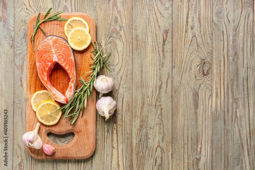 Raw salmon steak with garlic and lemon on wooden background Raw salmon steak with garlic and lemon on wooden background