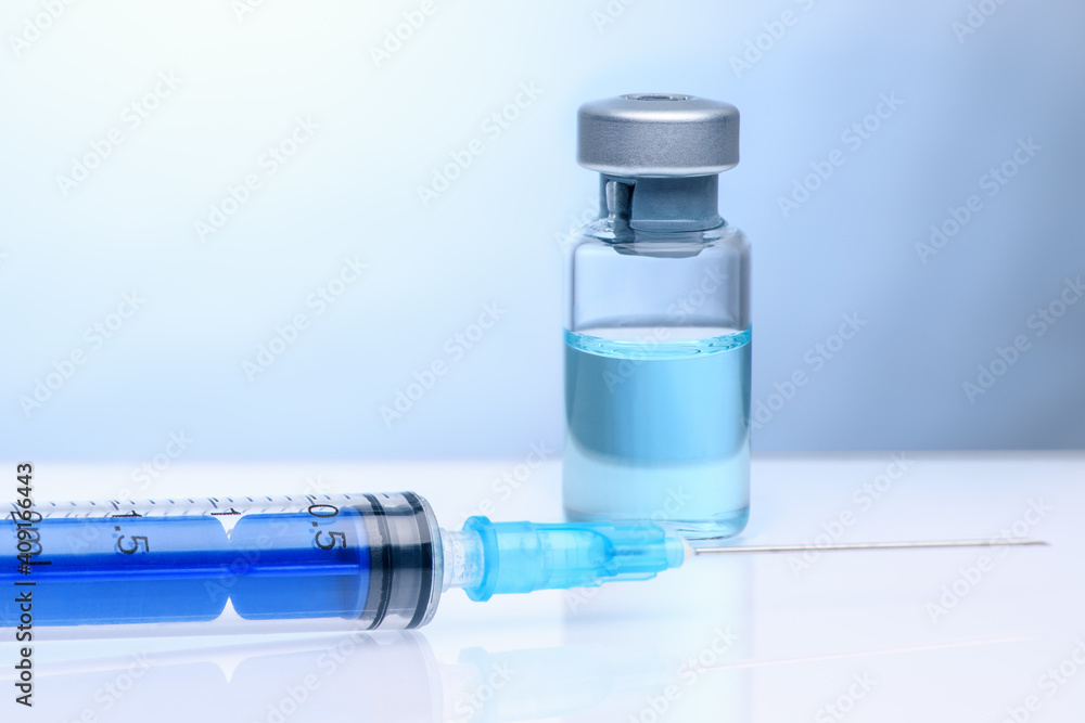 The coronavirus vaccine and syringe injection. Vial with vaccine against coronavirus on a light blue background. The concept of protection against coronavirus infection, COVID-19. The coronavirus vaccine and syringe injection. Vial with vaccine against coronavirus on a light blue background. The concept of protection against coronavirus infection, COVID-19.