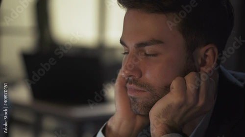 Portrait of young businessman, manager works late, overworked guy at work, a tired falls asleep in the workplace, night time. photo