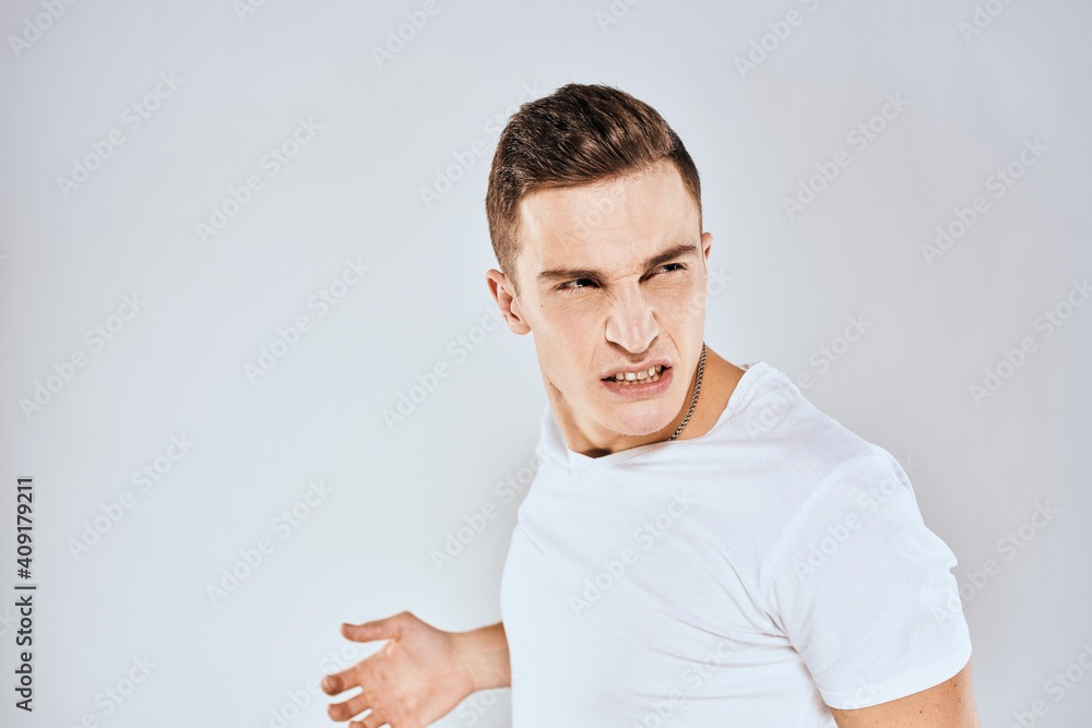 Man in white t-shirt displeased facial expression gesturing with hands studio lifestyle Man in white t-shirt displeased facial expression gesturing with hands studio lifestyle