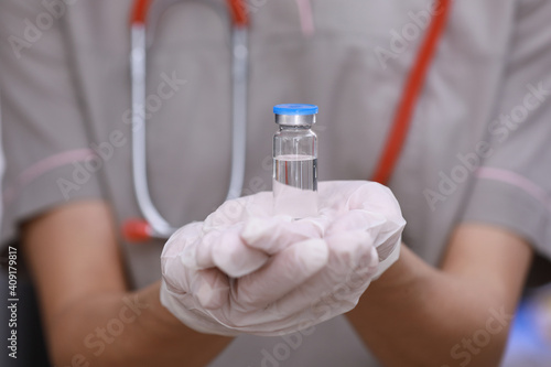Female doctor with a stethoscope on shoulder holding COVID-19 vaccine. Healthcare And Medical concept. Development and creation of a coronavirus vaccine.
