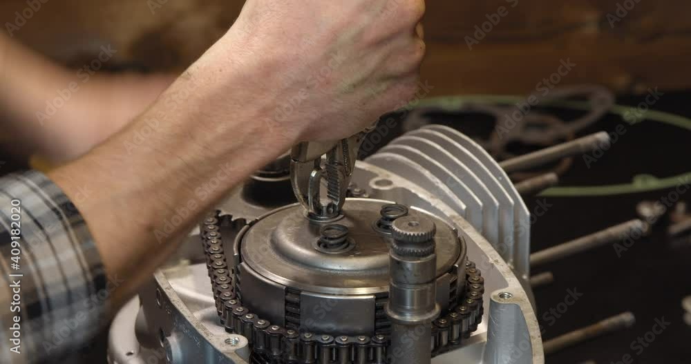 Classic motorcycle engine repair in workshop garage