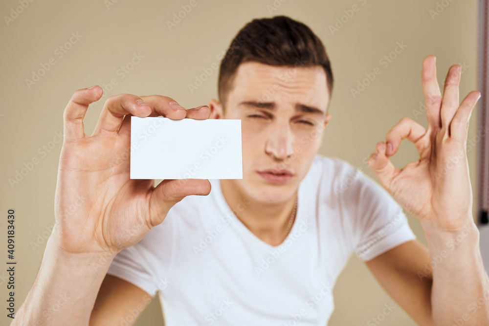 Man with a business card in the hands of an office manager beige background Copy Space Man with a business card in the hands of an office manager beige background Copy Space