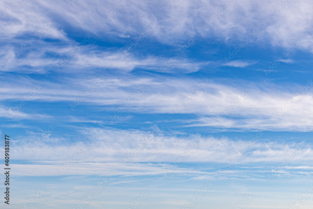 High white cirrus clouds with cirro-stratus in a light blue sky, sometimes called chair tails, indicate nice weather, but stormy changes come within a few days. White clouds in a blue sky. 