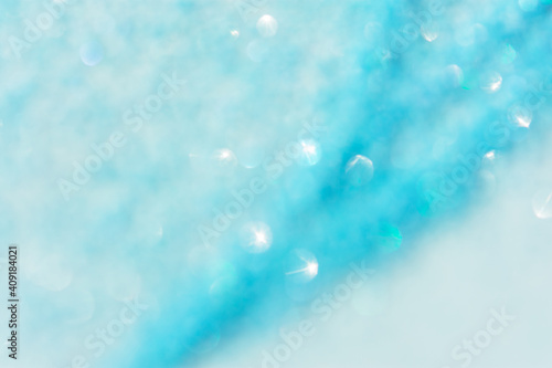 Abstract blue background with bokeh defocused. Fashionable bright turquoise color of sea water. Festive clean blue layout of a postcard, banner for the New year. The concept of the winter holidays.
