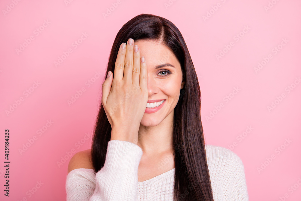 Portrait of young lovely pretty smiling happy positive cheerful girl cover half face with hand isolated on pink color background