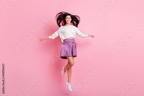 Full size photo of young attractive good mood smiling beautiful girl jumping isolated on pink color background
