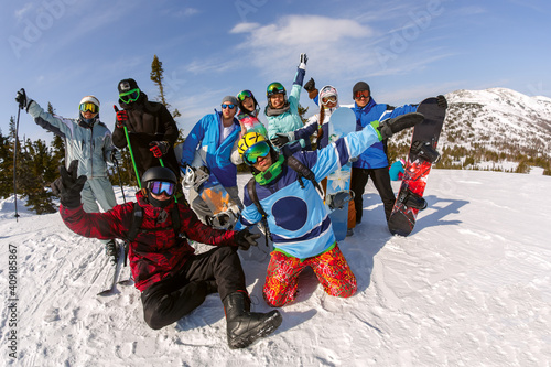 Group of friends snowboarders having fun on the top of mountain