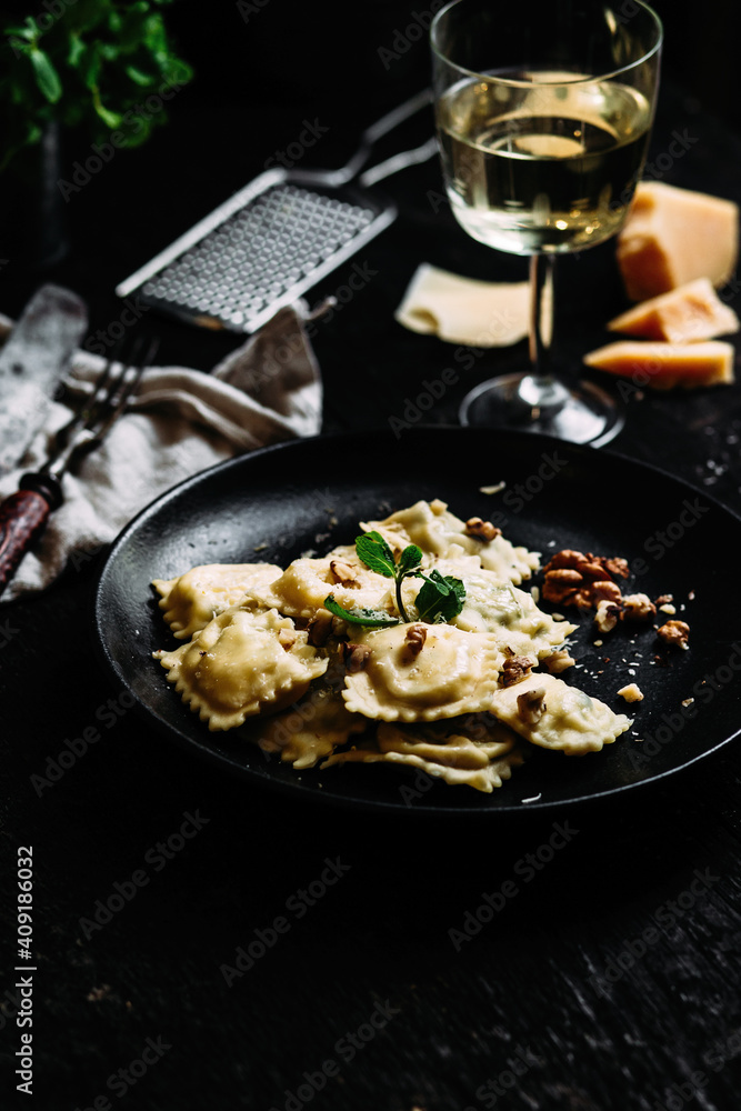 Ravioli with spinach, ricotta and parmesan on a black plate Ravioli with spinach, ricotta and parmesan on a black plate
