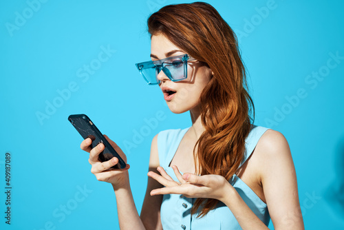 pretty woman in blue glasses with phone in hands communication technology isolated background
