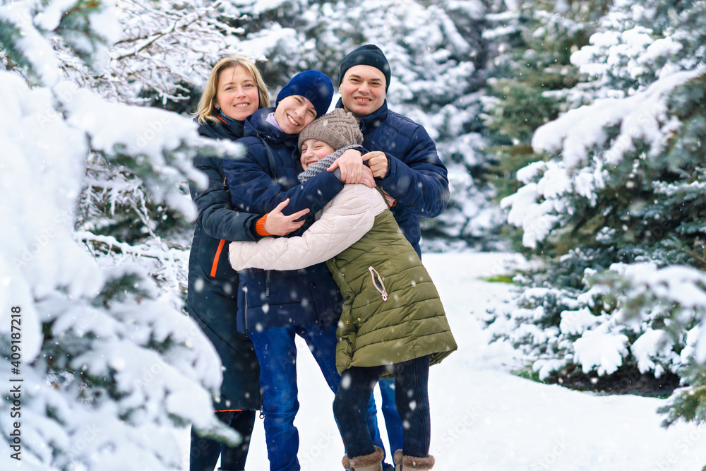 family portrait in the winter forest, parent and children, beautiful nature with bright snowy fir trees family portrait in the winter forest, parent and children, beautiful nature with bright snowy fir trees