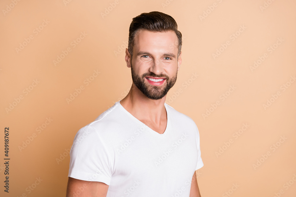 Photo of young handsome bristle man happy positive toothy smile confident isolated over beige color background Photo of young handsome bristle man happy positive toothy smile confident isolated over beige color background