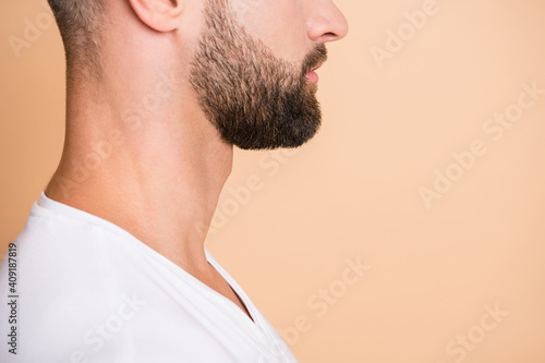 Cropped profile side photo of young handsome stubble man wear white t-shirt isolated over beige color background