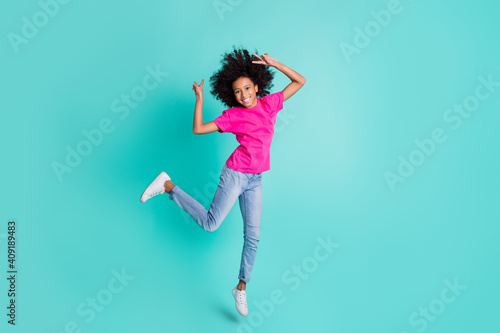Full size photo of young happy positive smiling cheerful girl jump showing v-sign isolated on turquoise color background
